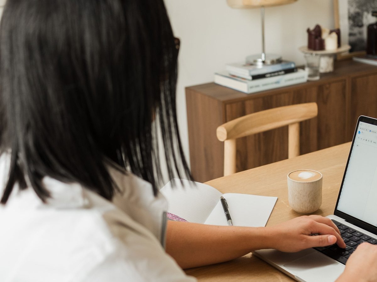 Zorgverlener werkt aan de keukentafel op haar laptop aan de administratie